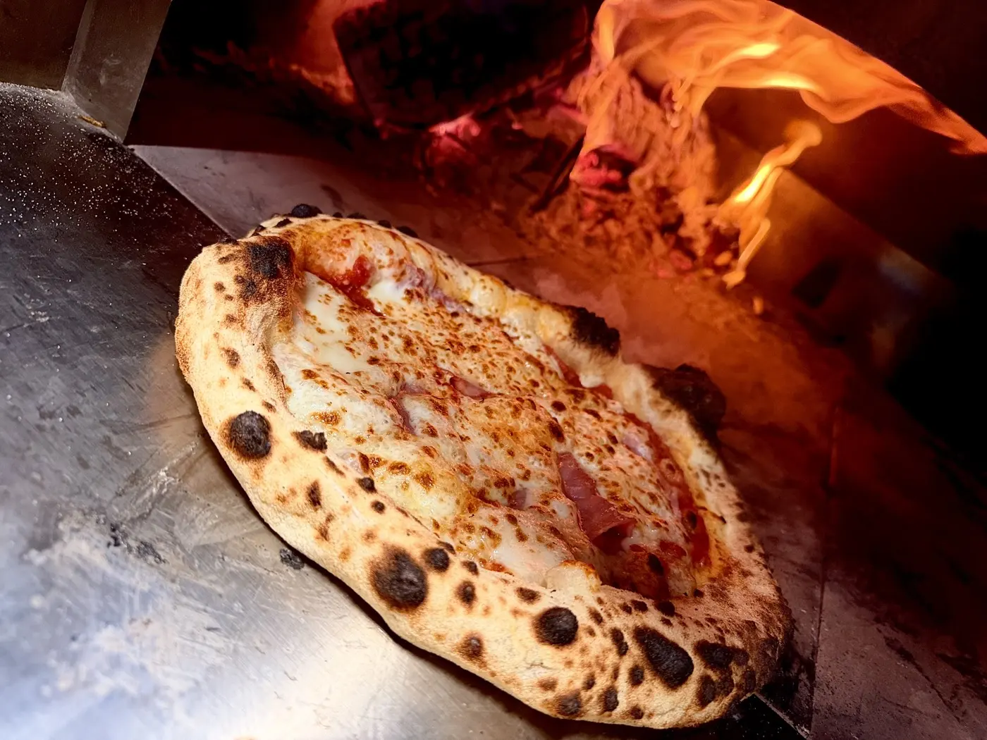 Pizza napolitaine en cuisson dans le four à bois de Casa Gianotti
